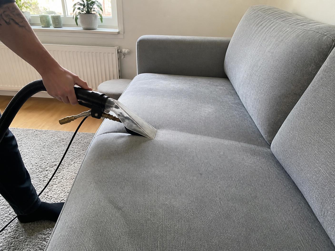 Tekstilrens av stoffsofa hjemme hos en kunde